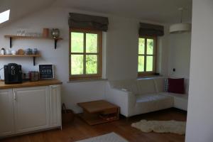a living room with a white couch and two windows at Biohof Schmiedbauer in Sankt Martin