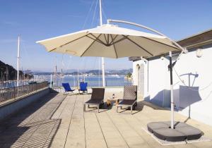 a patio with chairs and an umbrella on a roof at Terrazza Bello in Portovenere