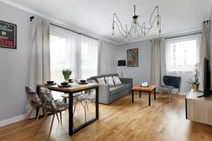 - un salon avec un canapé et une table avec des chaises dans l'établissement Short Stay Apartments, à Gdańsk