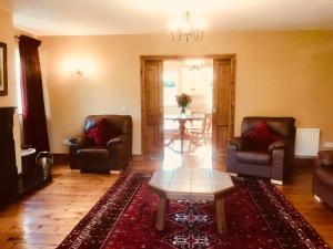 een woonkamer met 2 stoelen en een tafel bij The-Gables in Donegal