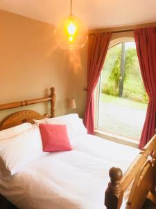 1 dormitorio con 1 cama blanca y ventana en The-Gables, en Donegal