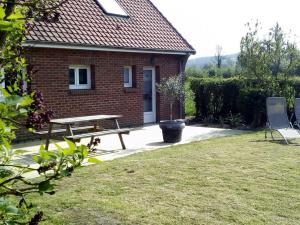 una casa de ladrillo con una mesa de picnic y un banco en La Hulotte au Col Haut en Audrehem