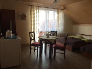 1 dormitorio con mesa, sillas y 1 cama en Graal Rewal en Rewal