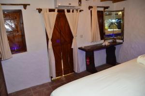 1 dormitorio con cama, espejo y ventana en Kaz Ladouceur, en La Digue