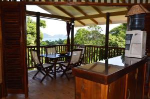 a porch with a table and chairs on a deck at Kaz Ladouceur in La Digue