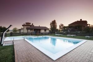 una grande piscina in un cortile con una casa di Poggio Mille a Castiglione del Lago