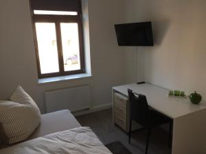 a bedroom with a desk and a bed and a window at Leipzig-in in Leipzig