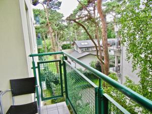 a balcony with a green railing and a tree at Apartament Jurata 30 in Jurata