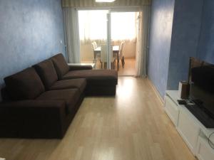 sala de estar con sofá y TV en Albamar Apartment, en Calpe