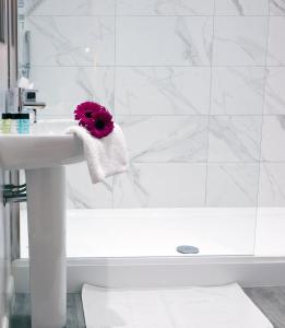a white bathroom with a sink and a bath tub at Sea Spray Hotel in Brighton & Hove