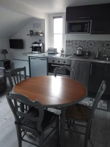 a kitchen with a wooden table and a table and chairs at Les Tournelles in Versailles