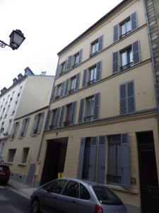 a building with a car parked in front of it at Les Tournelles in Versailles