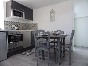 a kitchen with a table and chairs and a microwave at Les Tournelles in Versailles