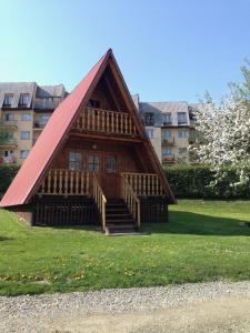 波蘭茲克的住宿－"Domek na Wiejskiej 4" Polańczyk , 696-025-331，公园里的一个红色屋顶小木屋