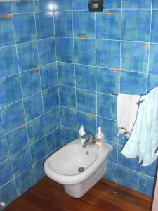 a blue tiled bathroom with a sink and towels at Barbara's House - Liguria in Santo Stefano al Mare +33 photos