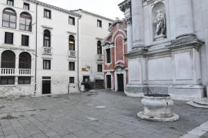 un bâtiment avec une statue au milieu d'une rue dans l'établissement B&B Cà Del Modena, à Venise