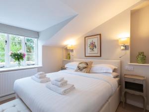 a bedroom with a large white bed with towels on it at 14 Vineyard Street in Winchcombe