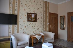 a room with two chairs and a table and a television at Willa Helena in Łeba