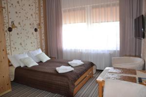 une chambre d'hôtel avec un lit et des serviettes. dans l'établissement Willa Helena, à Łeba