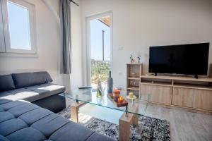 a living room with a couch and a tv at Joseph - superior sea bay and mountain view in Cavtat