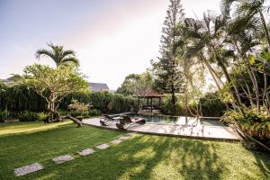 een tuin met een zwembad in een tuin bij Villa Puri Burung in Canggu