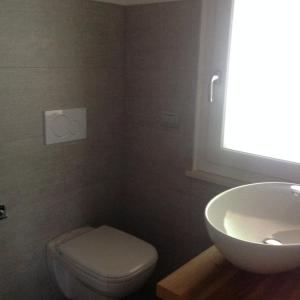 a bathroom with a white toilet and a sink at Rooms dei Minatori in Pergine Valsugana