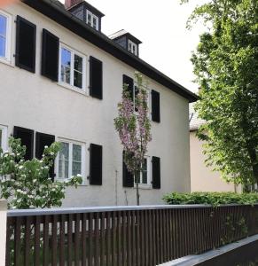ein Haus mit schwarzen Fensterläden und einem Baum in der Unterkunft Leipziger Logis in Leipzig