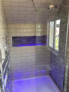 a bathroom with a shower with violet lights in it at Manhattan loft in Margate