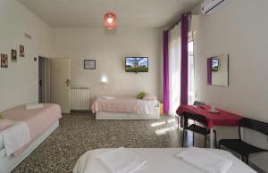 een kamer met 2 bedden en een rode tafel bij Aliante B&B in Pisa