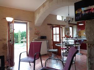 Huisseau-sur-CossonにあるGite du Colombier - Charme et Vieilles Pierresの椅子とテーブル、キッチンが備わる客室です。
