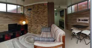 uma sala de estar com um sofá e uma parede de tijolos em O Ninho em Vila Nova de Gaia