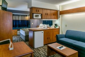 a small living room with a couch and a kitchen at Microtel Inn and Suites - Inver Grove Heights in Inver Grove Heights