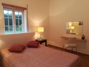 a bedroom with a bed with red pillows and a window at Praia Del Rei Beach 3 Pools in Amoreira