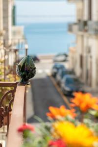 Blick auf einen Balkon mit Blumen auf einer Straße in der Unterkunft Torres Suite in Polignano a Mare