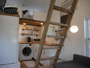 a room with a ladder and a washing machine at Hygge Tiny Home in Leeds