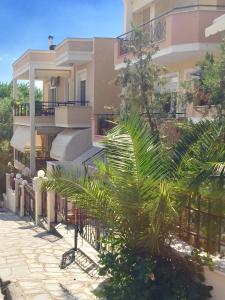 a building with a palm tree in front of it at Apartments@Tsiantas in Kavala