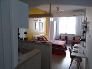 a room with a bed and a living room with a kitchen at Nice Studio in Copacabana in Rio de Janeiro