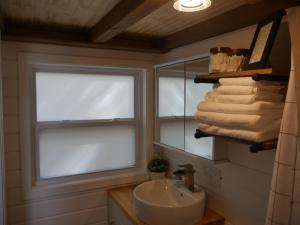 a bathroom with a sink and a window and towels at Hygge Tiny Home in Leeds +36 photos