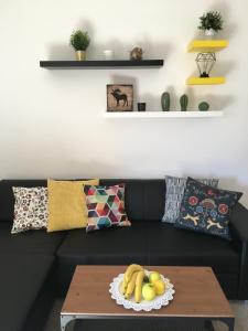 a living room with a black couch with a table at Penzión Salamander in Mlynky 