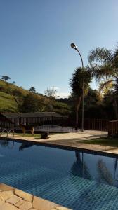 una piscina con un lampione e delle palme di Sítio da Dinda - Campos do Jordão a Rosas