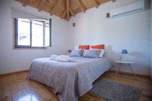 een witte slaapkamer met een groot bed met handdoeken erop bij LivingPorto Apartments by Porto City Hosts in Porto