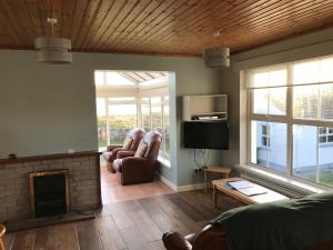 ein Wohnzimmer mit 2 Stühlen und einem Kamin in der Unterkunft Downings Coastguard Cottages - Type A in Downings