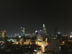 eine Skyline der Stadt in der Nacht mit beleuchteten Gebäuden in der Unterkunft Chez Mimosa Corner - New address 90 Đề Thám in Ho-Chi-Minh-Stadt