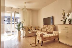 a living room with a couch and a tv at Apartament Golden Pearl Pogorzelica in Pogorzelica