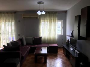 sala de estar con sofá y TV en Himara Apartment, en Himare