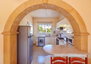 an archway in a kitchen with a table and a refrigerator at Hadjios Valley in Mazotos