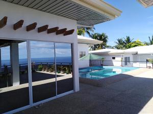 a house with a swimming pool and a view of the ocean at Seaview Mansion Apartment 1 in Dalaguete