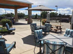 un patio con mesas, sillas y una sombrilla en Stay Wise Inns of Montrose en Montrose