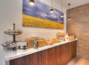 a breakfast buffet with a large painting on the wall at Hôtel WYLD Saint Germain ex Hotel Moderne Saint Germain in Paris