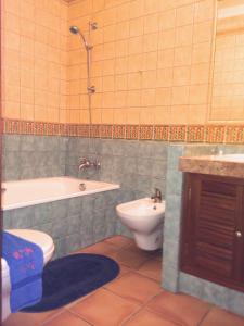 a bathroom with a tub and a toilet and a sink at Casa Rosa Azul - Terracos de Benagil (Cliffside) in Benagil